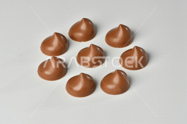 قالب قطع حلوى الشوكولاتة ، صناعة وإعداد حلوى الشوكولاته , مجموعة من حبات الشوكولاتة , حلويات مناسبات واستقبال , حلوى العيد , ترافل بالشوكولاتة , زبدة البندق مع الشوكولاتة، حلويات وسكريات , خلفية بيضاء .
