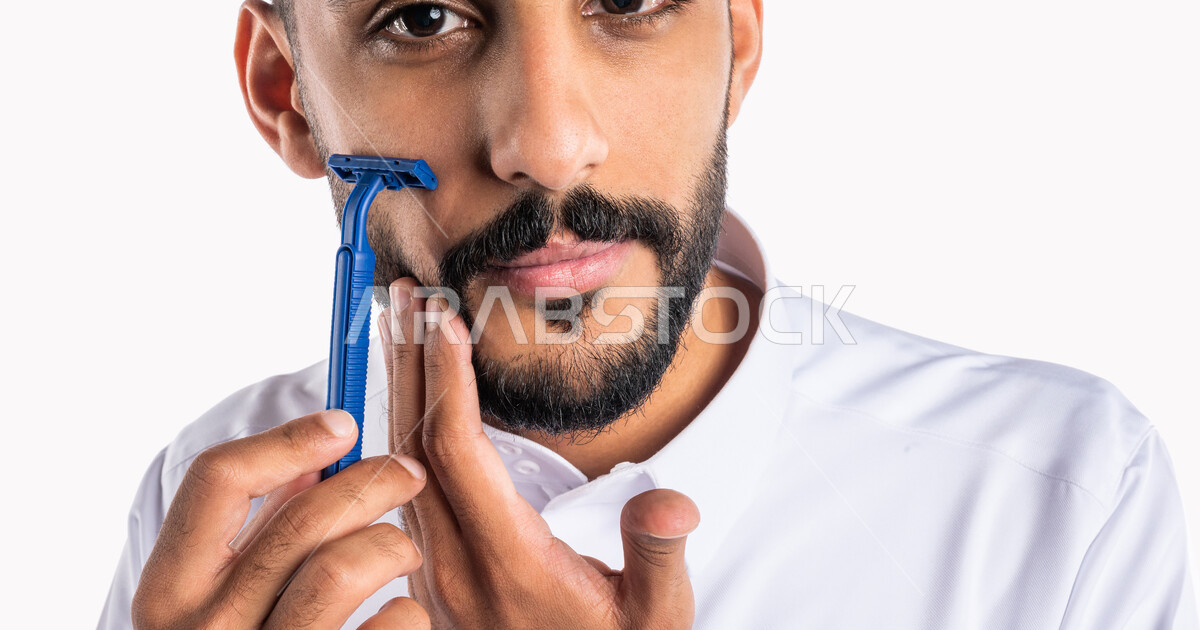Closeup portrait of a Saudi Arabian Gulf man, removing facial hair