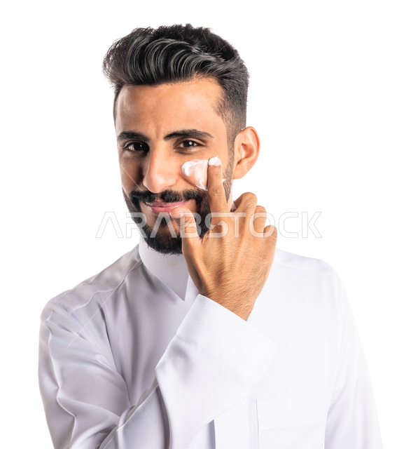 Closeup portrait of a Saudi Arabian Gulf man, applying moisturizing