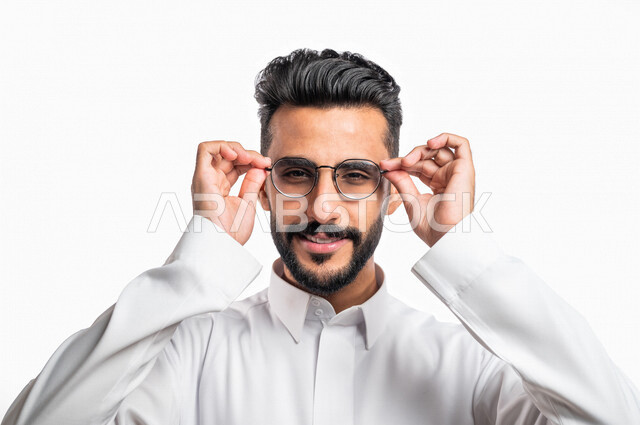 بورتريه بصورة مقربة لرجل عربي خليجي سعودي مبتسم ، ينظر إلى الكاميرا ،  يرتدي النظارة الطبية خاصة بضعف النظر ، الرؤية من خلال النظارة الطبية ، مفهوم ضعف البصر ، قصر النظر ، خلفية بيضاء