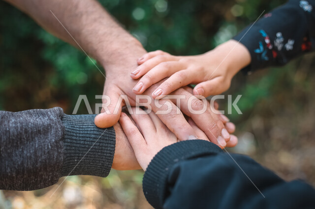 صوره مقربه لمجموعة أيادي فوق بعضها, مفهوم الإتحاد والقوه, العائله المتكاتفه, التعاون والمشاركه, الحب والحنان, العائله السعيده, العمل الجماعي