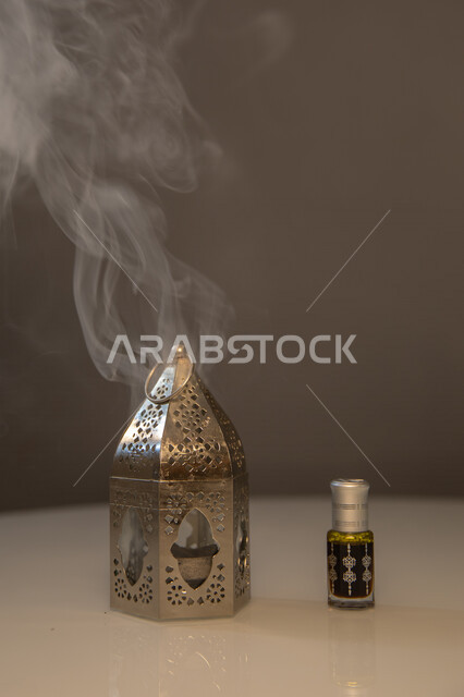 صورة مقربة لمبخرة بجانبها تولة عود، دهن العود الفاخر، التعطر والتطيب، بخور عربي، بخور خليجي سعودي، المسك والعود