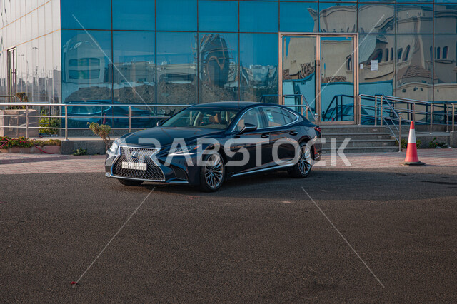 سيارة من نوع ليكزيس سوداء اللون امام مبنى زجاجي، سيارة فاخرة، سيارة سوداء امام واجهه زجاجية 