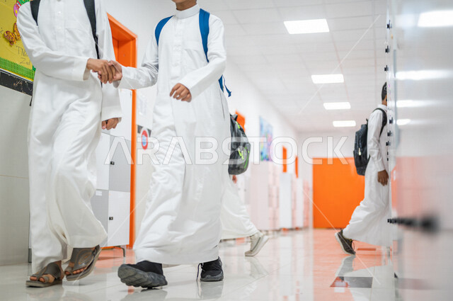 صورة مقربة لطالبان عربيان خليجيان سعوديان يتصافحان، تعارف وصداقات، العلاقات المترابطة، محبة وترابط ، لقاء و تواصل، المشي في ممرات المدرسة، العودة إلى المدارس، التعليم في المملكة العربية السعودية