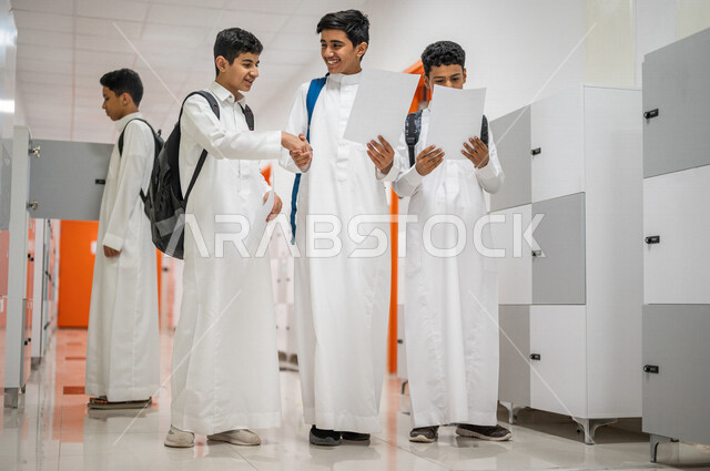 طالبان عربيان خليجيان سعوديان يتصافحان، مراجعة اوراق الامتحانات، تعارف وصداقات، العلاقات المترابطة، محبة وترابط ، لقاء و تواصل، المشي في ممرات المدرسة، ايماءات وجه مبتسمة، التعليم في المملكة العربية السعودية