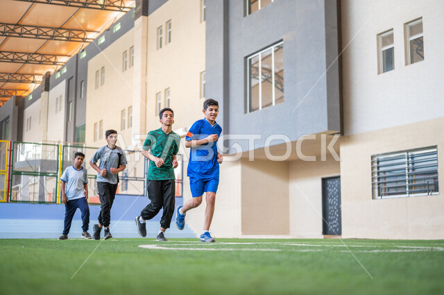 طلاب عرب خليجيين سعوديين يقومون باداء تمارين الاحماء، الجري في ملعب المدرسة، ممارسة التمارين الرياضية، حصة التربية الرياضية، التعليم في المملكة العربية السعودية