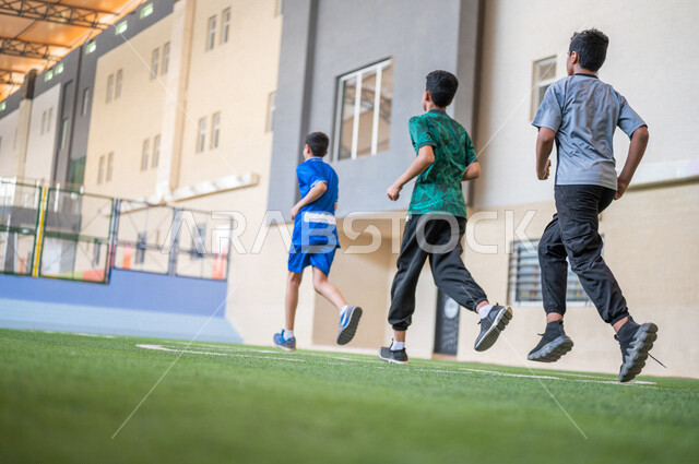 طلاب عرب خليجيين سعوديين يقومون باداء تمارين الاحماء، الجري في ملعب المدرسة، ممارسة التمارين الرياضية، حصة التربية الرياضية، التعليم في المملكة العربية السعودية