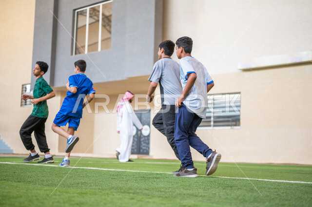 طلاب عرب خليجيين سعوديين يقومون باداء تمارين الاحماء، الجري في ملعب المدرسة، ممارسة التمارين الرياضية، حصة التربية الرياضية، التعليم في المملكة العربية السعودية