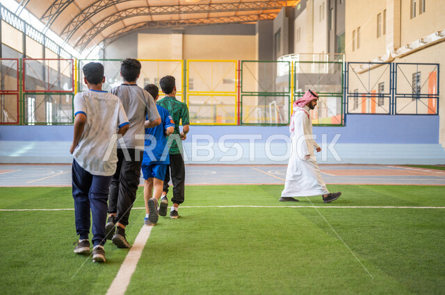 طلاب عرب خليجيين سعوديين يقومون باداء تمارين الاحماء، الجري في ملعب المدرسة، ممارسة التمارين الرياضية، حصة التربية الرياضية، التعليم في المملكة العربية السعودية