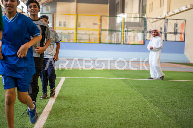 صورة مقربة لطلاب عرب خليجيين سعوديين يقومون باداء تمارين الاحماء، الجري في ملعب المدرسة، ممارسة التمارين الرياضية، حصة التربية الرياضية، التعليم في المملكة العربية السعودية