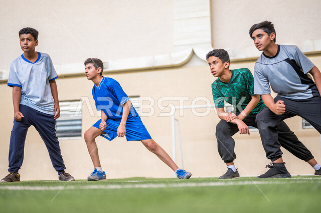 صورة مقربة لطلاب عرب خليجيين سعوديين يقومون باداء تمارين الاحماء، تمارين التمدد، ممارسة التمارين الرياضية، حصة التربية الرياضية، التعليم في المملكة العربية السعودية