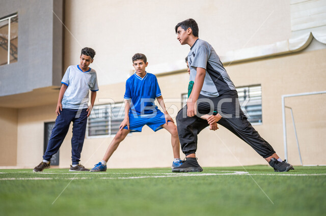 صورة مقربة لطلاب عرب خليجيين سعوديين يقومون باداء تمارين الاحماء، تمارين التمدد، ممارسة التمارين الرياضية، حصة التربية الرياضية، التعليم في المملكة العربية السعودية