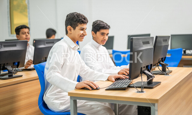 صورة مقربة لطلاب عرب خليجييون سعودييون في معمل الحاسب الآلي، استخدام الكمبيوتر في المدرسة، استخدام لوحة المفاتيح للكتابة، التعليم الالكتروني، المناهج المطورة، المشاركة الفعالة للطلاب، التعليم الفعال، التعليم في المملكة العربية السعودية