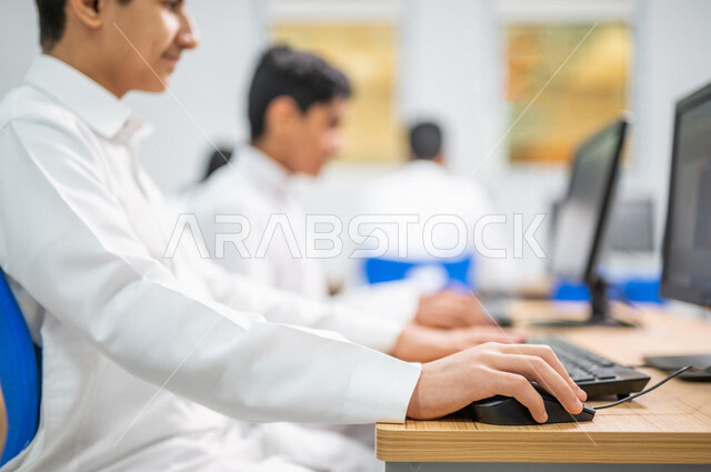 صورة مقربة لطلاب عرب خليجييون سعودييون في معمل الحاسب الآلي، استخدام الكمبيوتر في المدرسة، استخدام لوحة المفاتيح للكتابة، التعليم الالكتروني، المناهج المطورة، المشاركة الفعالة للطلاب، التعليم الفعال، التعليم في المملكة العربية السعودية