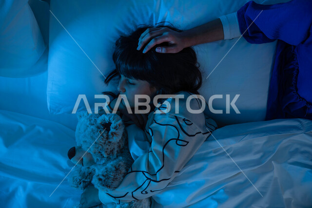 صوره مقربه لطفله عربية خليجية سعودية مع والدتها على السرير، وقت النوم, النوم المبكر, الإستمتاع بنوم هاديء ومريح, تربية الأبناء، مفهوم الترابط الأسري، حنان الأم على الأطفال