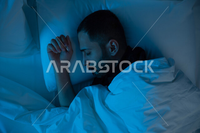 صوره مقربه لرجل عربي خليجي سعودي مستلقي على فراشه، النوم الباكر, النوم المريح, نوم صحي في الليل, النوم بعد التعب, سرير مريح, الإسترخاء والنوم