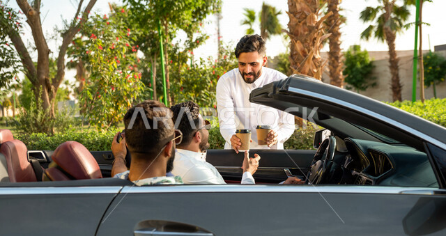 A close-up photo of a group of young Saudi Arabs from the Gulf on a car trip, buying coffee from the road, car orders, a luxury convertible car, strolling in the streets of the Kingdom, a youth trip in the car, chatting and conversations on the road, spen