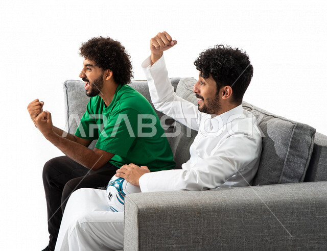 بورتريه لشابان عربيان خليجيان سعوديان يشجعان منتخب السعودية لكرة القدم، متابعة مباراة كرة القدم، شاب يمسك بيده كرة القدم، النجاح والقوة، تحقيق الاهداف، السعادة بالفوز، ايماءات وجه ويدين تدل على التشجيع والحماس، كأس العالم 2022، مونديال قطر، خلفية بيضاء