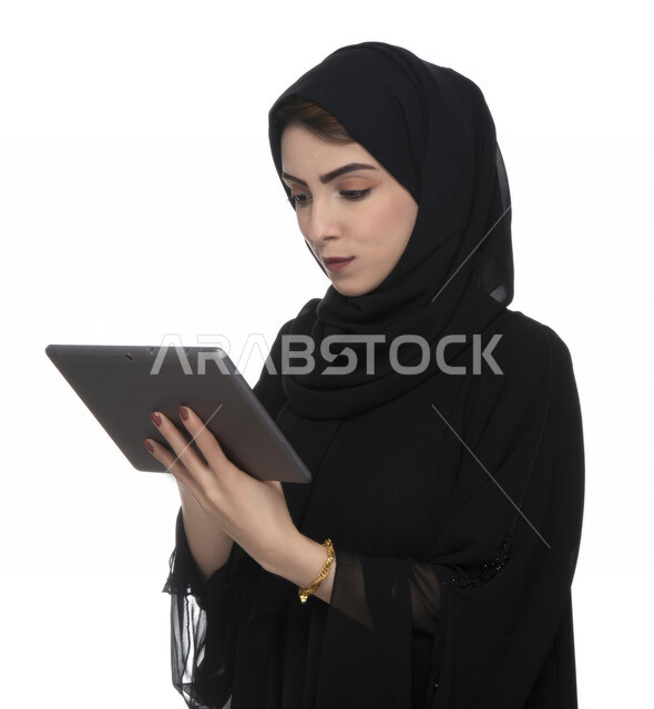 بورتريه لإمرأة عربيه خليجيه إماراتية بالزي التقليدي تستخدم جهاز لوحي  ، التسويق الإلكتروني ، مفهوم التكنولوجيا وإستخدام الأجهزة التقنية الحديثة ، العمل عن بعد  , مكالمة فيديو , مشاهدة البرامج , خلفية بيضاء 