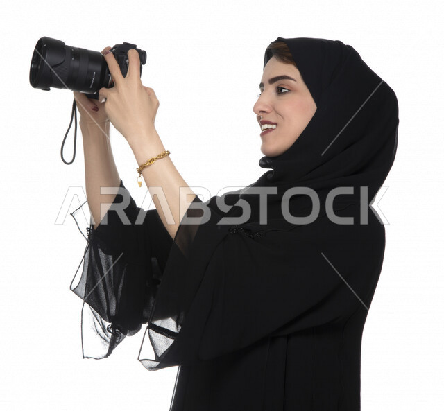 Portrait of an Arab Gulf Emirati young woman, holding a camera in her hand, taking pictures using the camera, photography, talent and professionalism in the art of photography, Emirati photographer, high-resolution camera, white background