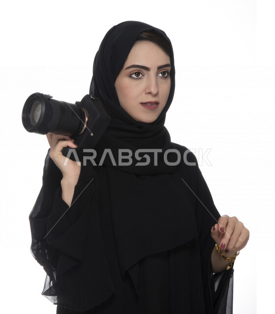 بورتريه لشابه عربيه خليجيه إماراتيه ، تحمل بيدها كاميرة التصوير ، تلتقط الصور باستخدام كاميرا التصوير ، التصوير الفوتوغرافي ، موهبة واحتراف فن التصوير ، مصوره إماراتية  ، كاميرا عالية الدقة ، خلفية بيضاء 