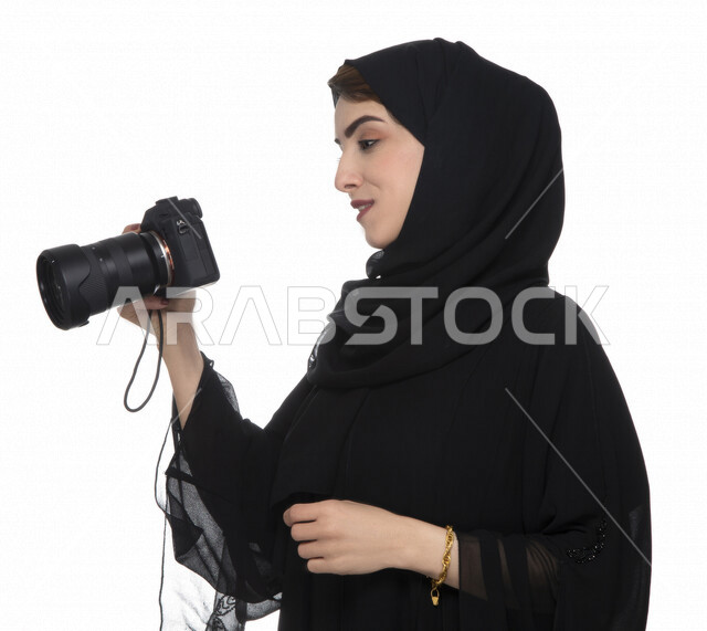 بورتريه لشابه عربيه خليجيه إماراتيه ، تحمل بيدها كاميرة التصوير ، تلتقط الصور باستخدام كاميرا التصوير ، التصوير الفوتوغرافي ، موهبة واحتراف فن التصوير ، مصوره إماراتية  ، كاميرا عالية الدقة ، خلفية بيضاء 