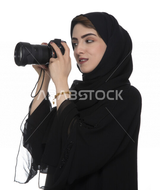 بورتريه لشابه عربيه خليجيه إماراتيه ، تحمل بيدها كاميرة التصوير ، تلتقط الصور باستخدام كاميرا التصوير ، التصوير الفوتوغرافي ، موهبة واحتراف فن التصوير ، مصوره إماراتية  ، كاميرا عالية الدقة ، خلفية بيضاء 