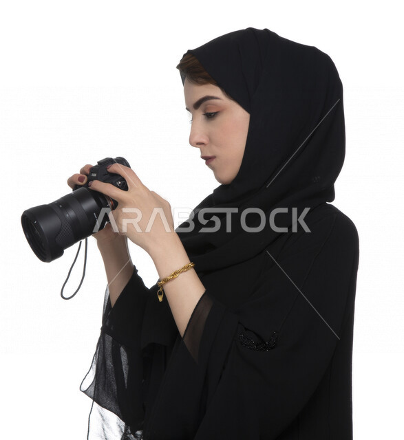 بورتريه لشابه عربيه خليجيه إماراتيه ، تحمل بيدها كاميرة التصوير ، تلتقط الصور باستخدام كاميرا التصوير ، التصوير الفوتوغرافي ، موهبة واحتراف فن التصوير ، مصوره إماراتية  ، كاميرا عالية الدقة ، خلفية بيضاء 