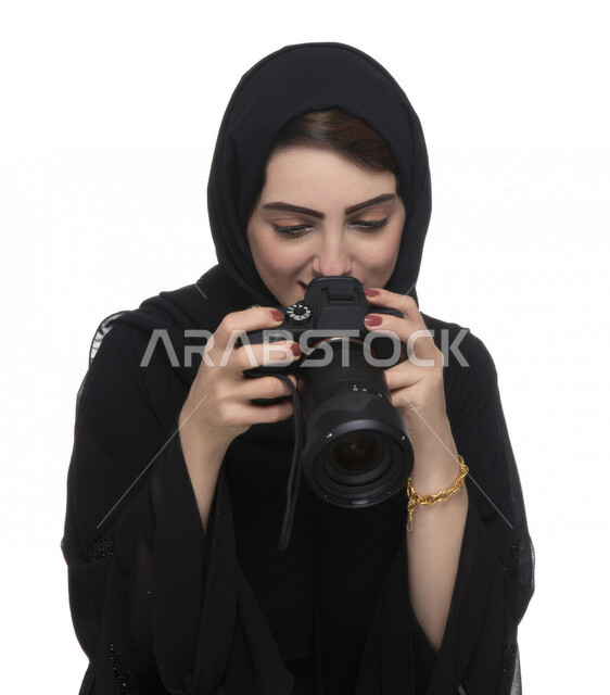 بورتريه لشابه عربيه خليجيه إماراتيه ، تحمل بيدها كاميرة التصوير ، تلتقط الصور باستخدام كاميرا التصوير ، التصوير الفوتوغرافي ، موهبة واحتراف فن التصوير ، مصوره إماراتية  ، كاميرا عالية الدقة ، خلفية بيضاء 