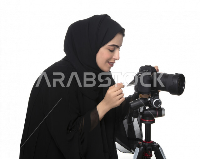 بورتريه لشابه عربيه خليجيه إماراتيه ، تحمل بيدها كاميرة التصوير ، تلتقط الصور باستخدام كاميرا التصوير ، التصوير الفوتوغرافي ، موهبة واحتراف فن التصوير ، مصوره إماراتية  ، كاميرا عالية الدقة ، خلفية بيضاء 