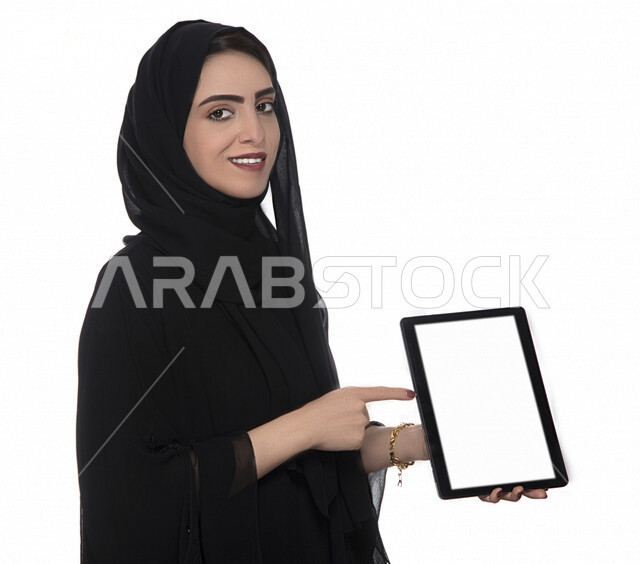 Portrait of an Emirati woman using a tablet, technology and computer, distance purchasing, distance education, video games, white background
