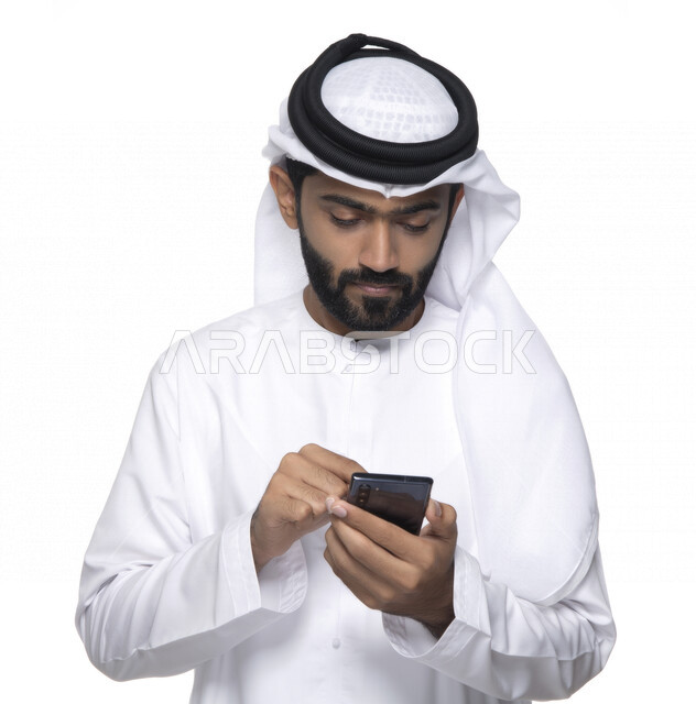 بورتريه لشاب عربي خليجي إماراتي يستعمل هاتف المحمول ، إيماءات وجه تدل على التركيز ,  التواصل مع الأفراد ، طلبات أونلاين و تسويق ، علاقات اجتماعية  ، استخدام أجهزة تقنية ، خلفية بيضاء