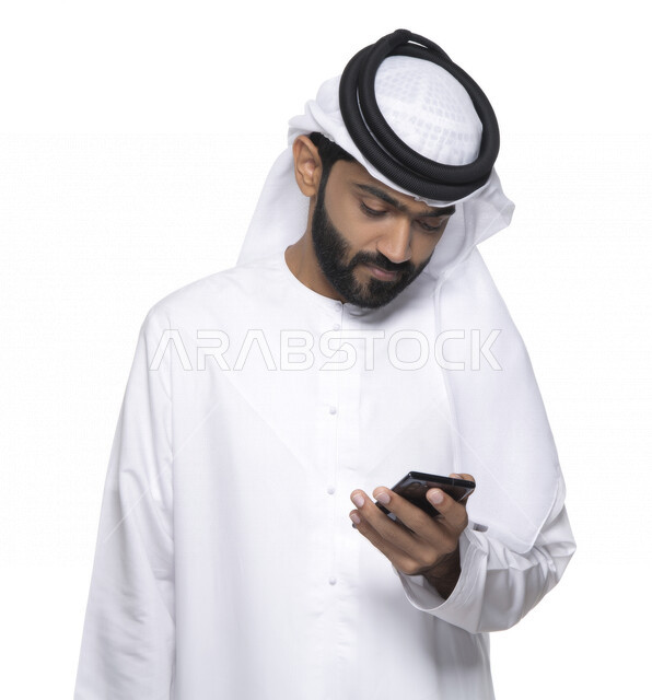 بورتريه لشاب عربي خليجي إماراتي يستعمل هاتف المحمول ، إيماءات وجه تدل على التركيز ,  التواصل مع الأفراد ، طلبات أونلاين و تسويق ، علاقات اجتماعية  ، استخدام أجهزة تقنية ، خلفية بيضاء