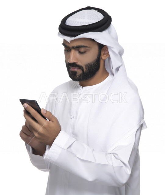 بورتريه لشاب عربي خليجي إماراتي يستعمل هاتف المحمول ، إيماءات وجه تدل على التركيز ,  التواصل مع الأفراد ، طلبات أونلاين و تسويق ، علاقات اجتماعية  ، استخدام أجهزة تقنية ، خلفية بيضاء