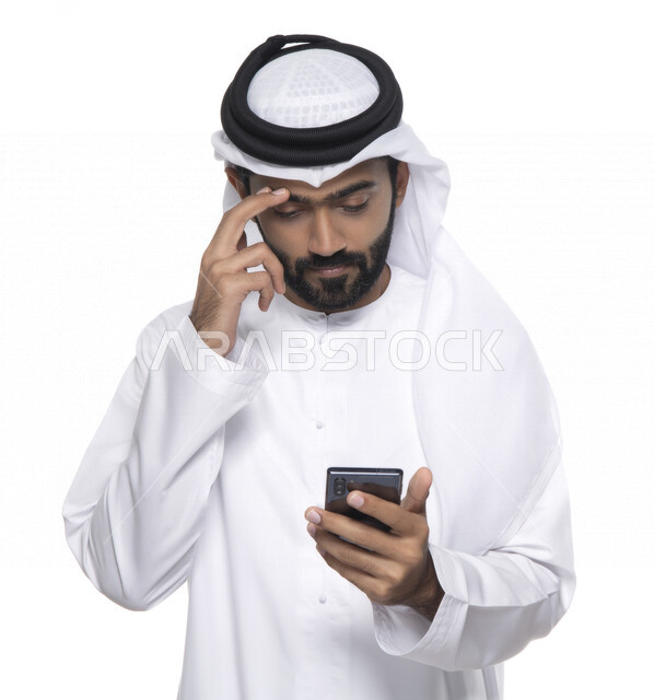 بورتريه لشاب عربي خليجي إماراتي يستعمل هاتف المحمول ، إيماءات وجه تدل على التركيز ,  التواصل مع الأفراد ، طلبات أونلاين و تسويق ، علاقات اجتماعية  ، استخدام أجهزة تقنية ، خلفية بيضاء