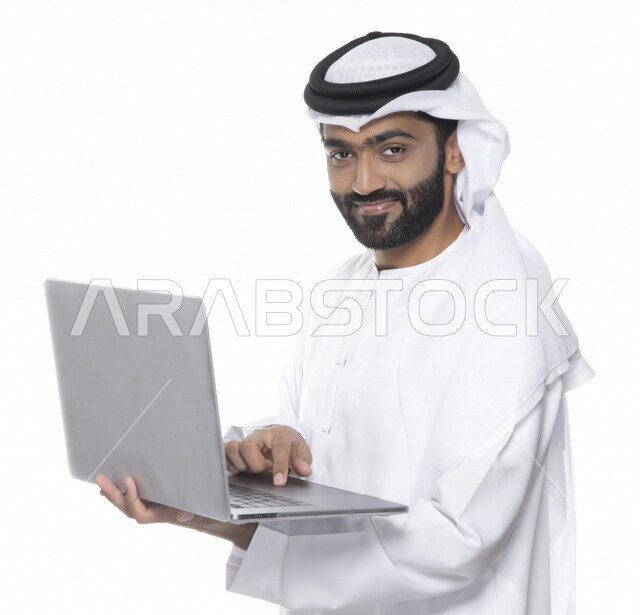 بورتريه لرجل أعمال عربي خليجي إماراتي يستخدم جهاز الحاسوب المحمول لإنجاز المهام، جلسة عمل، إنجاز المشاريع والمهام، مهن وأعمال تجارية، متابعة ومناقشة العمل، عقد إجتماع عمل عبر الإنترنت، التسويق الإلكتروني، خلفية بيضاء 
