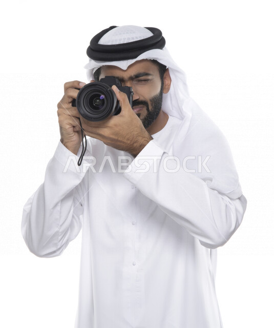 بورتريه لشاب عربي خليجي إماراتي ، يحمل بيده كاميرا التصوير ، يلتقط الصور باستخدام كاميرا التصوير ، التصوير الفوتوغرافي ، موهبة واحتراف فن التصوير ، مصور إماراتي  ، كاميرا عالية الدقة ، خلفية بيضاء 