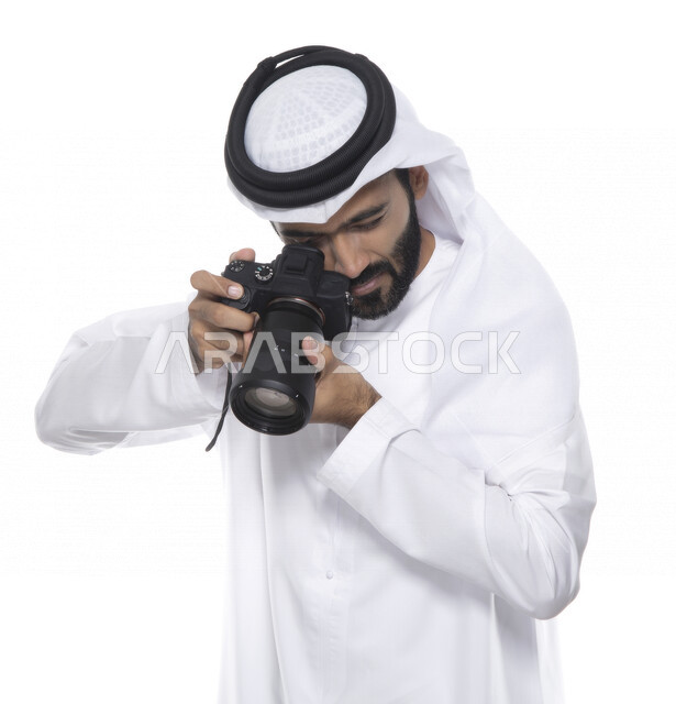 بورتريه لشاب عربي خليجي إماراتي ، يحمل بيده كاميرا التصوير ، يلتقط الصور باستخدام كاميرا التصوير ، التصوير الفوتوغرافي ، موهبة واحتراف فن التصوير ، مصور إماراتي  ، كاميرا عالية الدقة ، خلفية بيضاء 