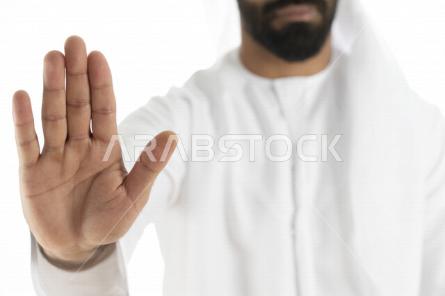 بورتريه لرجل عربي إماراتي خليجي يرتدي الزي الإماراتي , إيماءات يدين تدل على الأمر بالتوقف عن فعل شيء ما, الشعور بالخوف و الإنزعاج, الرفض والإمتناع , خلفية بيضاء