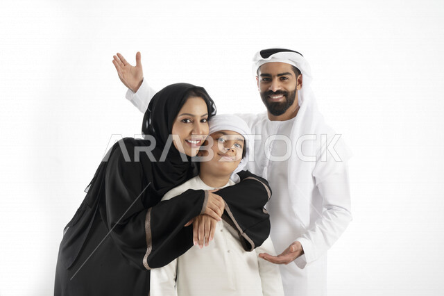 بورتريه لزوجان عربيان خليجيان إماراتيان بجانب إبنهم يرتديان  الزي الإماراتي التقليدي , قضاء وقت ممتع مع العائلة , إيماءات وجه تدل على السعادة والفرح , خلفية بيضاء 