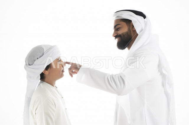 بورتريه لرجل عربي إماراتي خليجي مع ابنه بايماءات وجه و يدين مختلفة ، تجمع عائلي ، تعابير وجه ، قضاء أوقات عائلية ، خلفية بيضاء