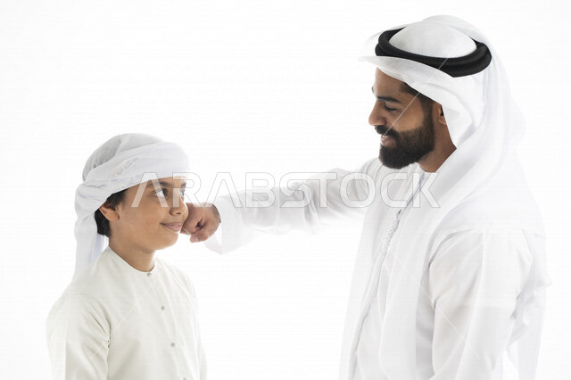 بورتريه لرجل عربي إماراتي خليجي مع ابنه بايماءات وجه و يدين مختلفة ، تجمع عائلي ، تعابير وجه ، قضاء أوقات عائلية ، خلفية بيضاء