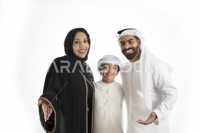 بورتريه لزوجان عربيان خليجيان إماراتيان بجانب إبنهم يرتديان  الزي الإماراتي التقليدي , قضاء وقت ممتع مع العائلة , إيماءات وجه تدل على الاندهاش ,  خلفية بيضاء 