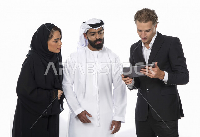 فريق عمل اماراتي ورجل بالبدلة الرسمية في اجتماع عمل ، إستخدام جهاز التابلت المحمول، متابعة مهام العمل، شركة اماراتية ، بيئة عمل ، زملاء عمل ، الشراكة والتعاون، إجتماع عمل، مناقشة ومتابعة الاعمال, تحقيق استراتيجيات وأهداف العمل , خلفية بيضاء .