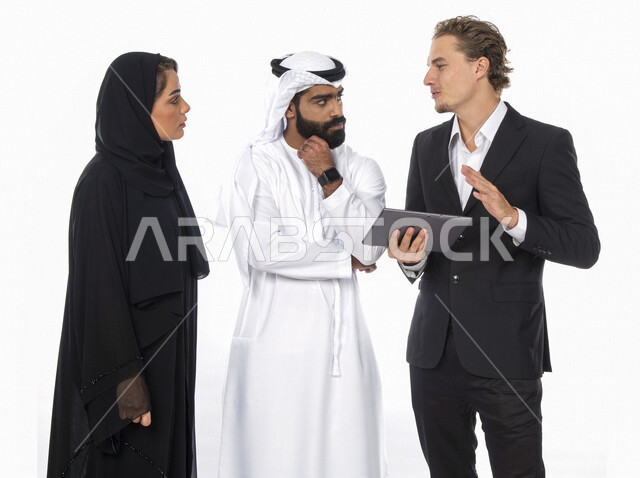 فريق عمل اماراتي ورجل بالبدلة الرسمية في اجتماع عمل ، إستخدام جهاز التابلت المحمول، متابعة مهام العمل، شركة اماراتية ، بيئة عمل ، زملاء عمل ، الشراكة والتعاون، إجتماع عمل، مناقشة ومتابعة الاعمال, تحقيق استراتيجيات وأهداف العمل , خلفية بيضاء .