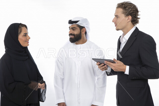 فريق عمل اماراتي ورجل بالبدلة الرسمية في اجتماع عمل ، إستخدام جهاز التابلت المحمول، متابعة مهام العمل، شركة اماراتية ، بيئة عمل ، زملاء عمل ، الشراكة والتعاون، إجتماع عمل، مناقشة ومتابعة الاعمال, تحقيق استراتيجيات وأهداف العمل , خلفية بيضاء .
