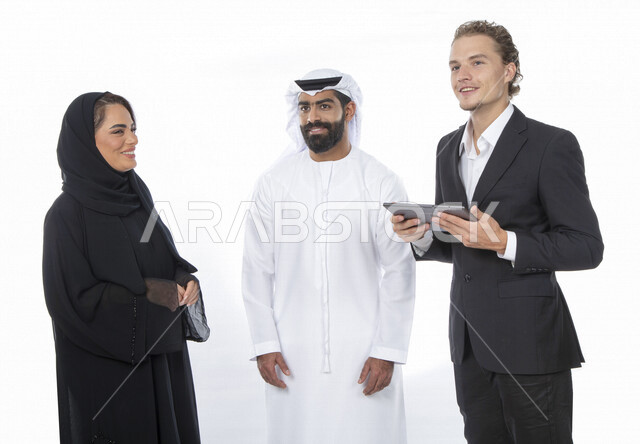 فريق عمل اماراتي ورجل بالبدلة الرسمية في اجتماع عمل ، إستخدام جهاز التابلت المحمول، متابعة مهام العمل، شركة اماراتية ، بيئة عمل ، زملاء عمل ، الشراكة والتعاون، إجتماع عمل، مناقشة ومتابعة الاعمال, تحقيق استراتيجيات وأهداف العمل , خلفية بيضاء .