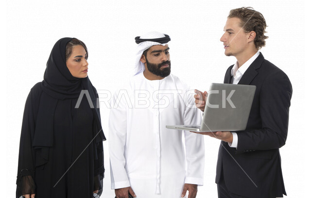 فريق عمل اماراتي ورجل بالبدلة الرسمية في اجتماع عمل ، إستخدام جهاز الحاسوب المحمول، متابعة مهام العمل، شركة اماراتية ، بيئة عمل ، زملاء عمل ، الشراكة والتعاون، إجتماع عمل، مناقشة ومتابعة الاعمال, تحقيق استراتيجيات وأهداف العمل , خلفية بيضاء .