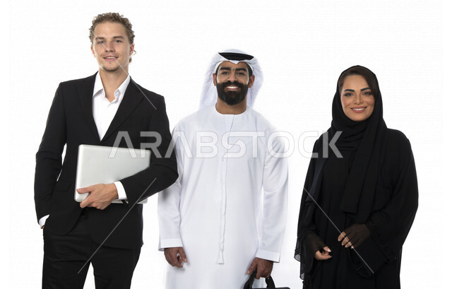 فريق عمل اماراتي ورجل بالبدلة الرسمية يقفون امام الكاميرا لأخذ صورة تذكارية ، استخدام تقنية جهاز الحاسوب المحمول ، متابعة مهام العمل، شركة اماراتية ، بيئة عمل ، زملاء عمل ، الشراكة والتعاون، إجتماع عمل، مناقشة ومتابعة الاعمال, تحقيق استراتيجيات وأهداف الع