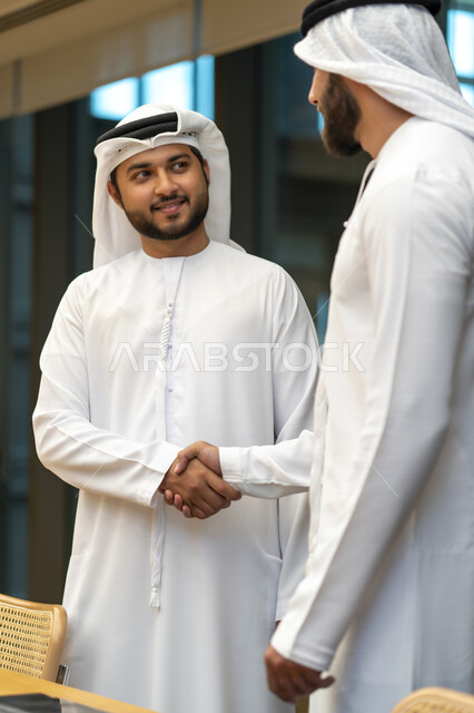 رجلا اعمال عربيان إماراتيان خليجيان يتصافحان، الإتفاق والشراكة على الأعمال والمشاريع التجارية، شركاء عمل، صفقة عمل جديده, التعاون بين الشركات، بيئة عمل إماراتيه، إتفاقية عمل, شركات عربيه إماراتيه خليجيه في الإمارات العربيه المتحده